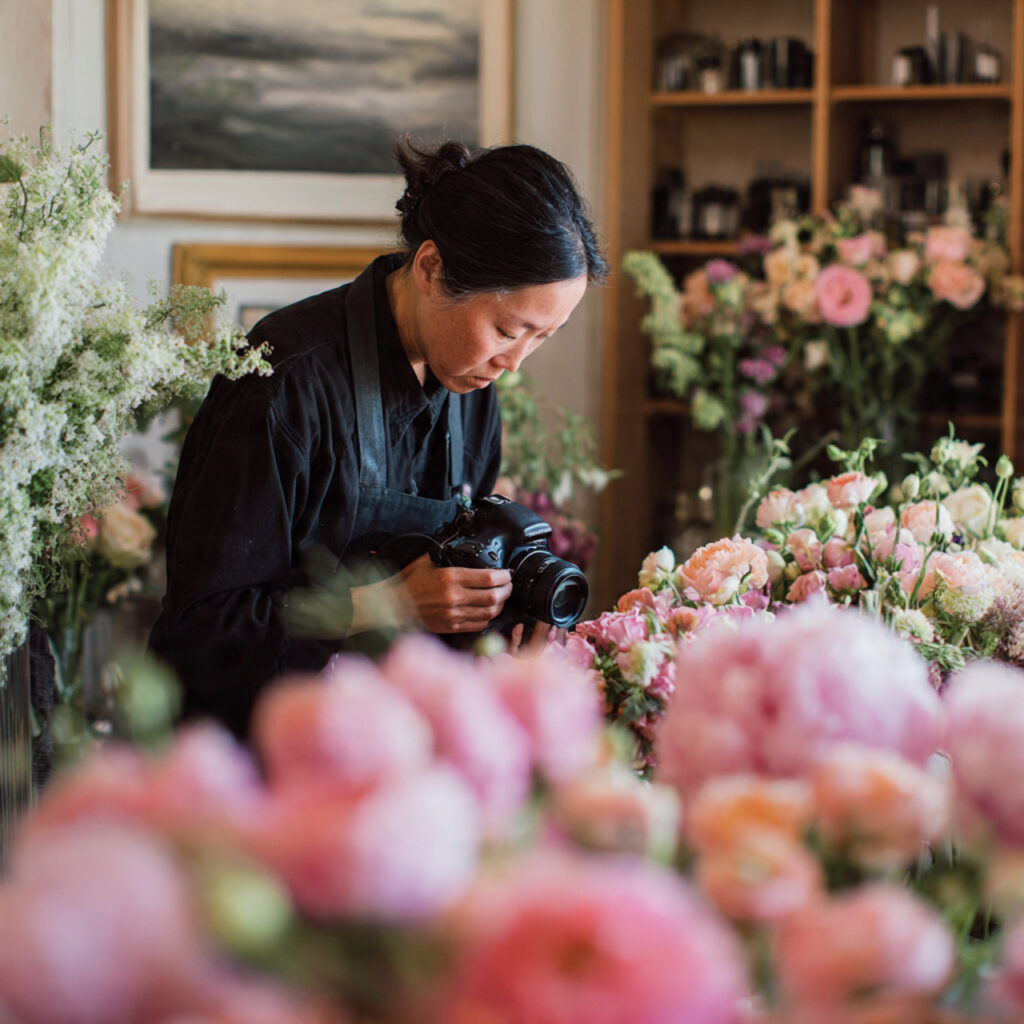 wedding florist arranging flowers behind the scenes floral design
